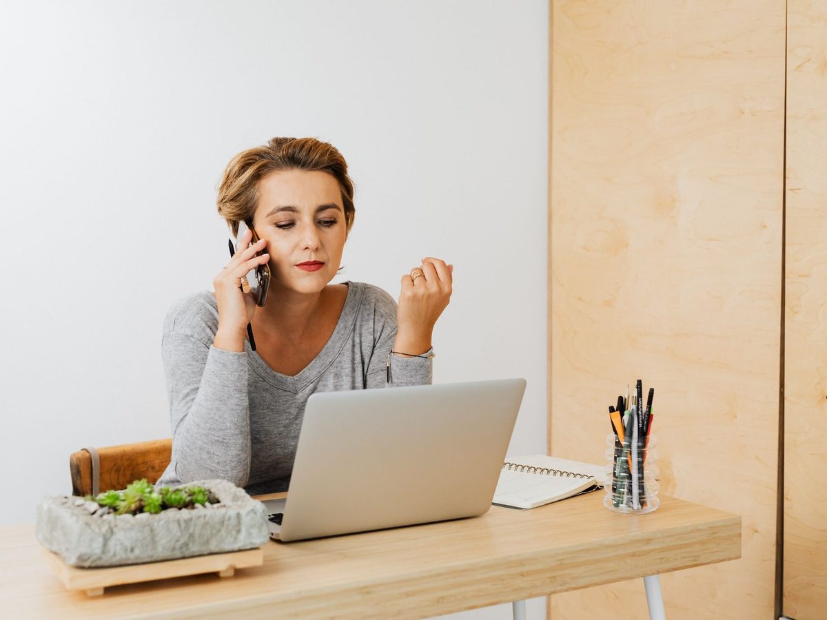 A broker working at a laptop while taking a call